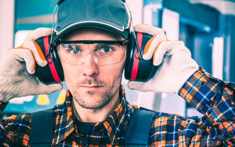 man wearing earmuffs, safety glasses and a hat