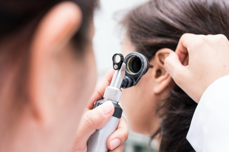doctor using otoscope on patients ear