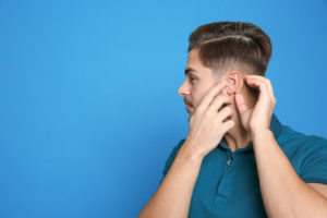person putting in otc hearing aids